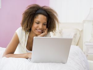 girl on computer in bed